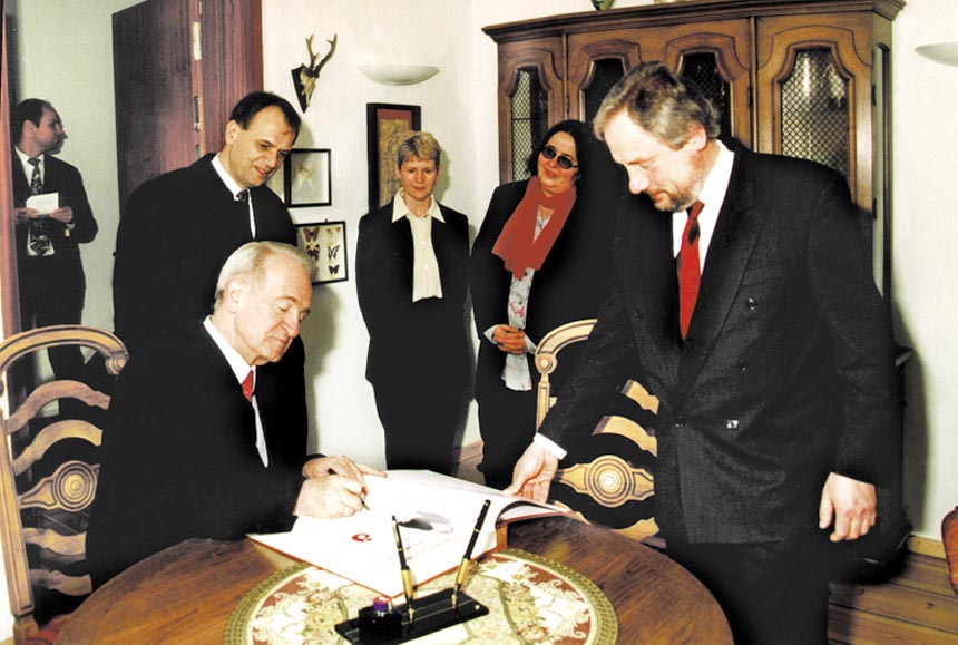 Prezydent RFN Johannes Rau †  i premier Reinhart Höppner † wpisują się do księgi gości fundacji; z prawej przewodniczący zarządu fundacji Heinz-Erhard Woltert.